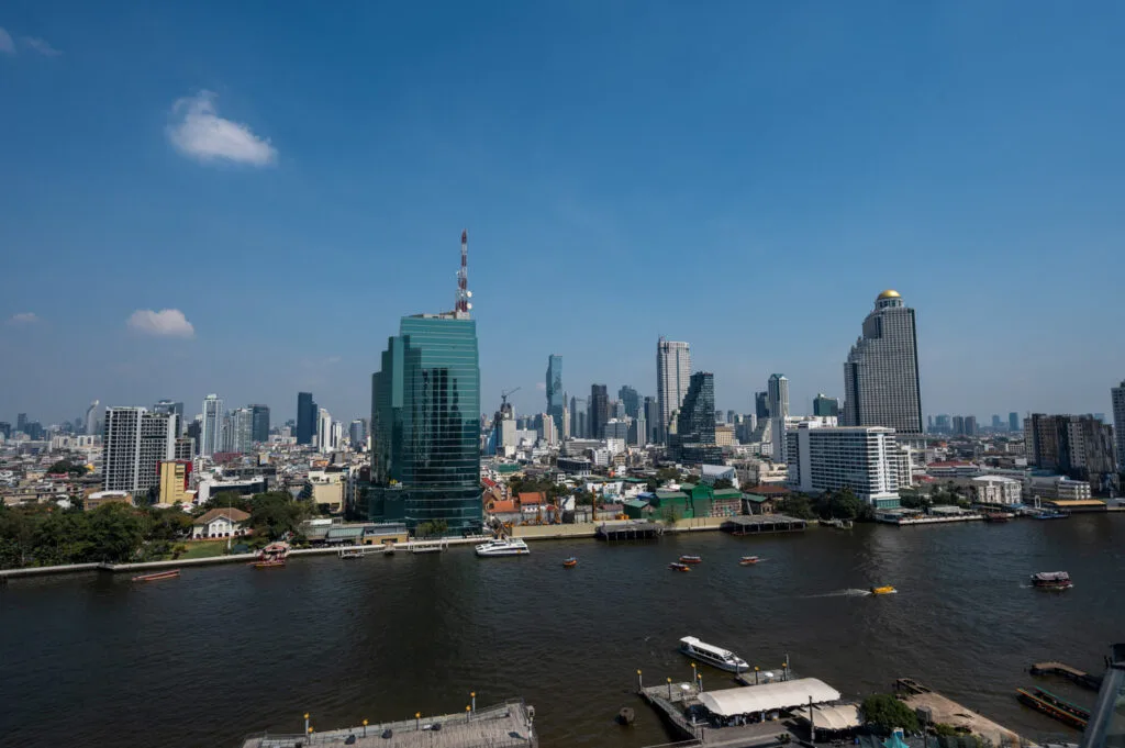 Blick vom Thonburi-Ufer auf den Chao Phraya und die Skyline von Bangkok
