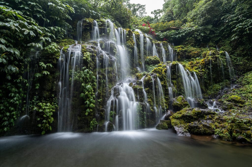 Mit Moos bewachsener Wasserfall an den Banyu Wana Amertha Wasserfällen in Munduk auf Bali