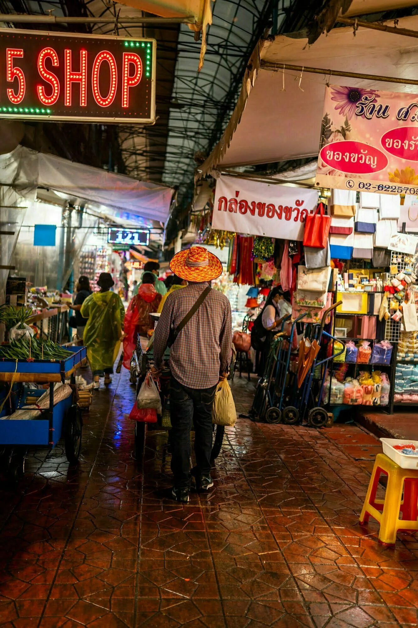 Belebte Gasse während eines leichten Regenschauers in Bangkok