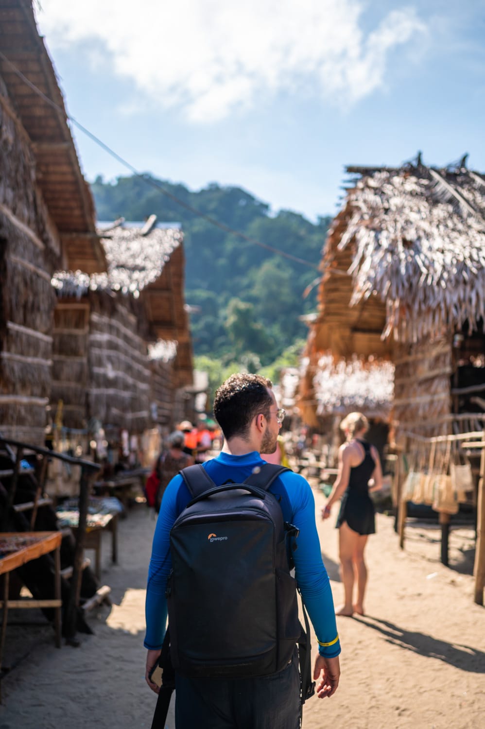 Nils Alexander Kemna läuft mit Fotorucksack durch das Dorf der Moken auf einer Tour von Khao Lak zu den Surin Islands