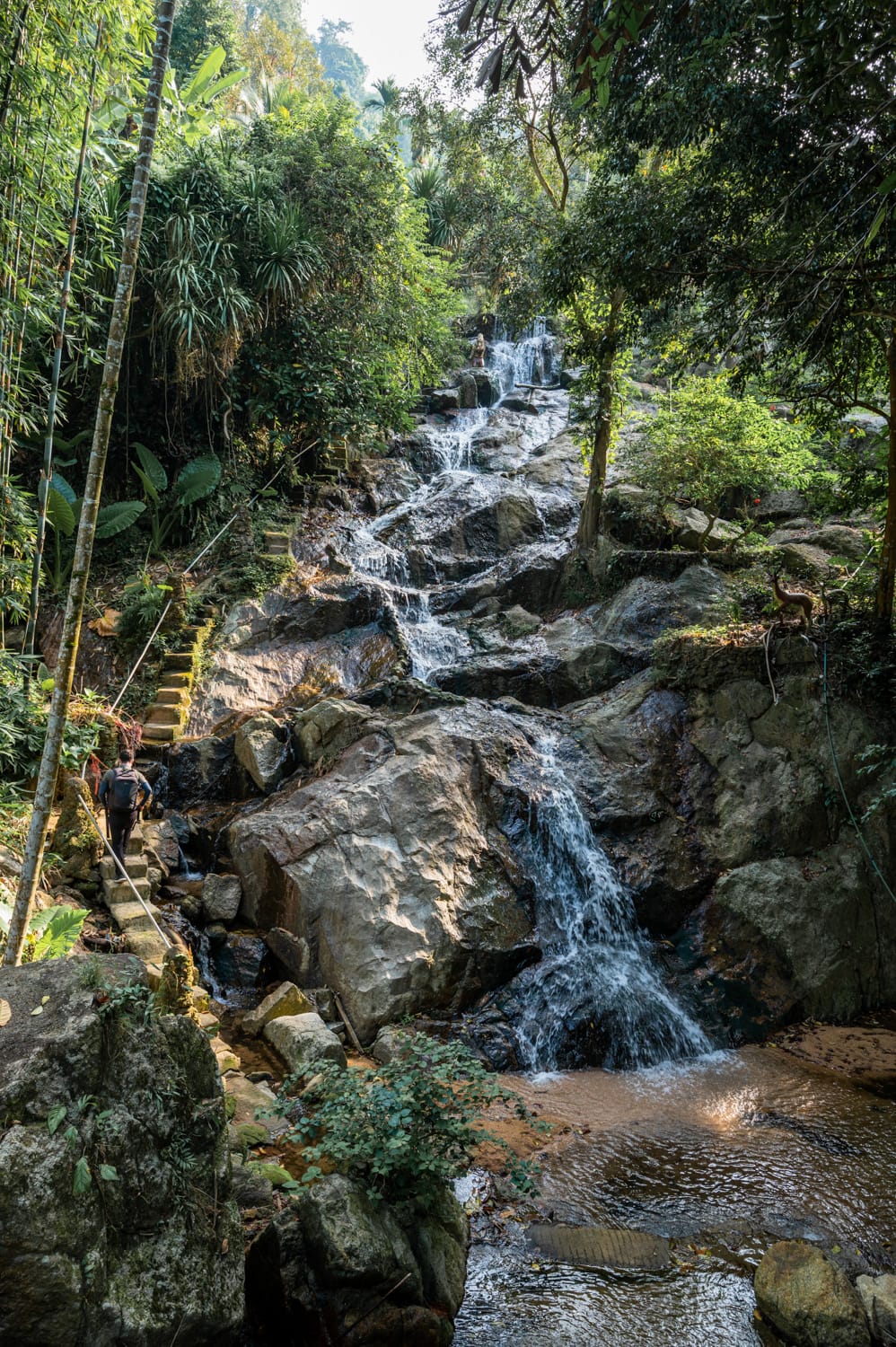Khao Yai Wasserfall Nils Alexander Kemna läuft entlang von Stufen den Khao Yai Wasserfall auf Koh Samui hinauf