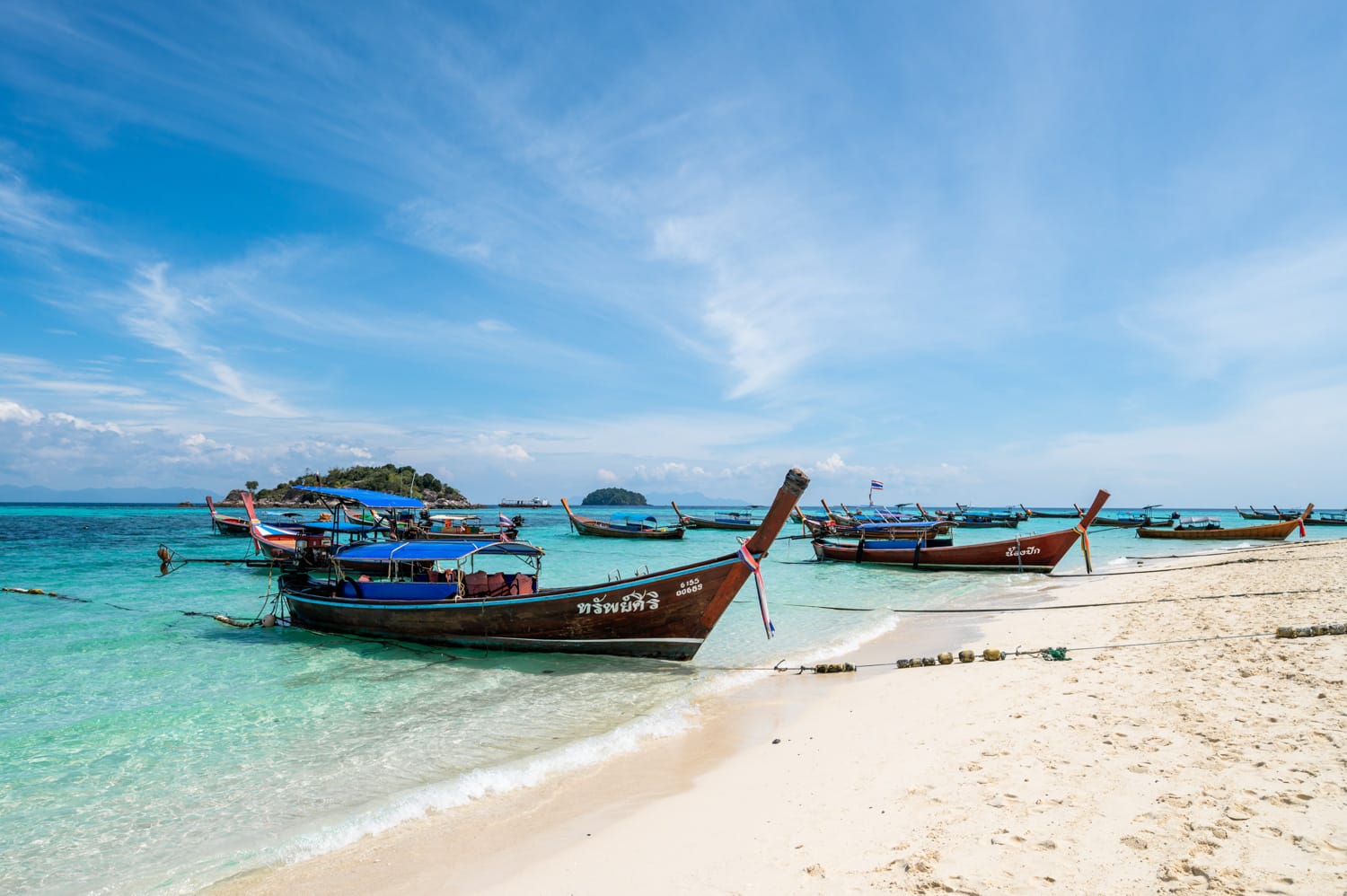 Viele Longtailboote ankern vor den Hotels am zentralen Abschnitt des Sunrise Beach auf Koh Lipe