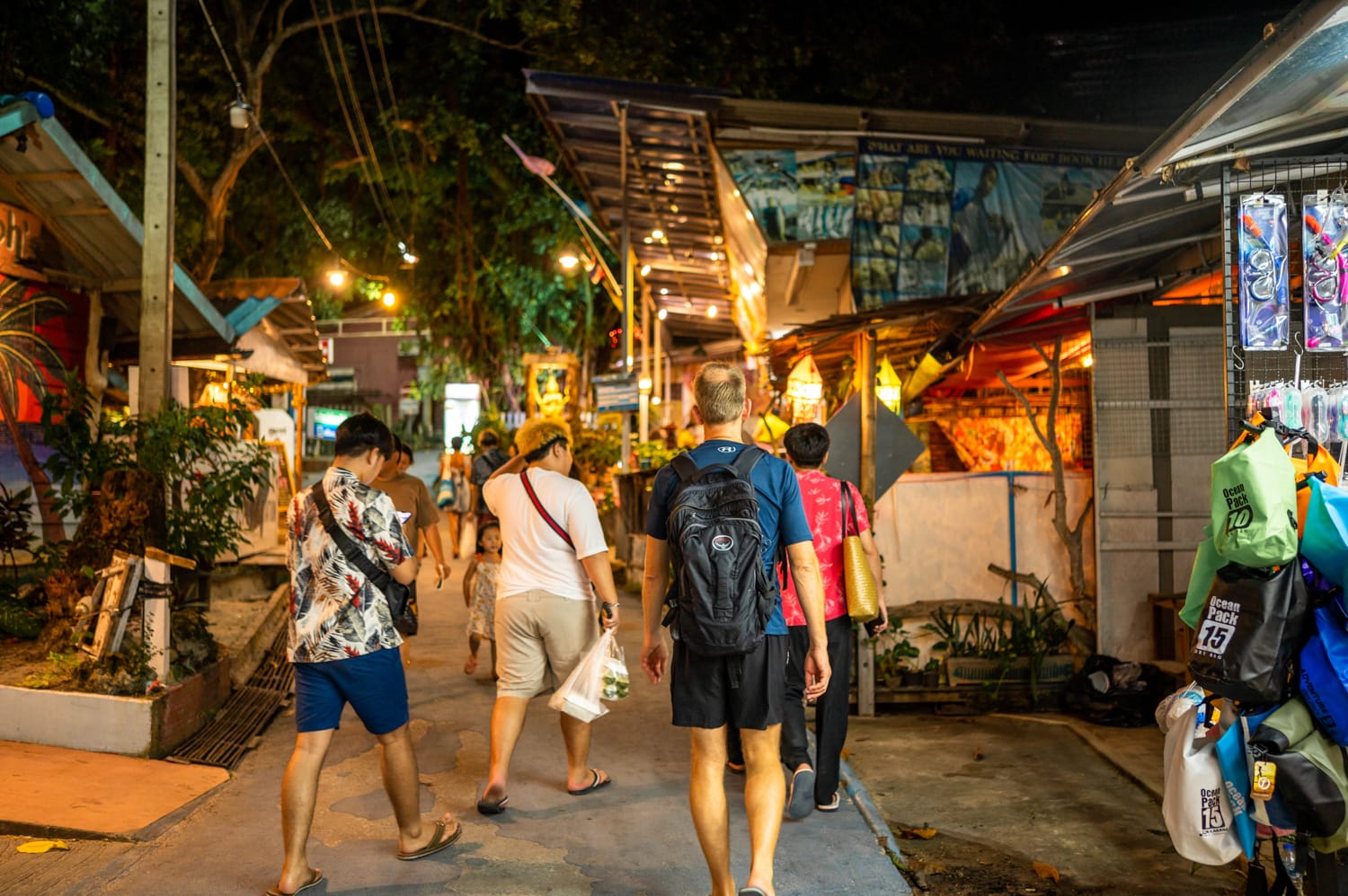 Touristen laufen am Abend über die belebte Walking Street auf Koh Lipe