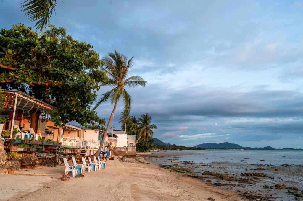 Unterkünfte und Bars blicken zum Sonnenuntergang am Bang Makham Beach nach Westen