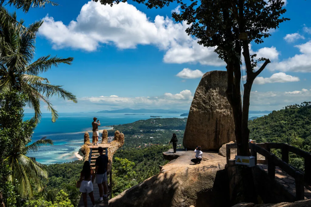 Ausblick auf den Overlap Stone 2 auf Koh Samui und Touristen, die Fotos auf der künstlichen Hand machen