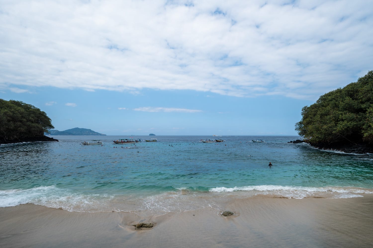 Urlauber baden und schnorcheln am Blue Lagoon Beach in Padang Bai auf Bali
