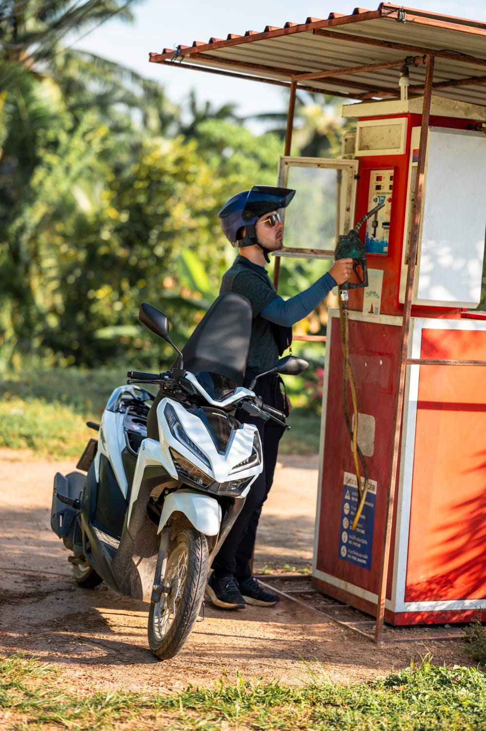 Nils Alexander Kemna tankt einen Roller an einem Tankautomaten in Thailand