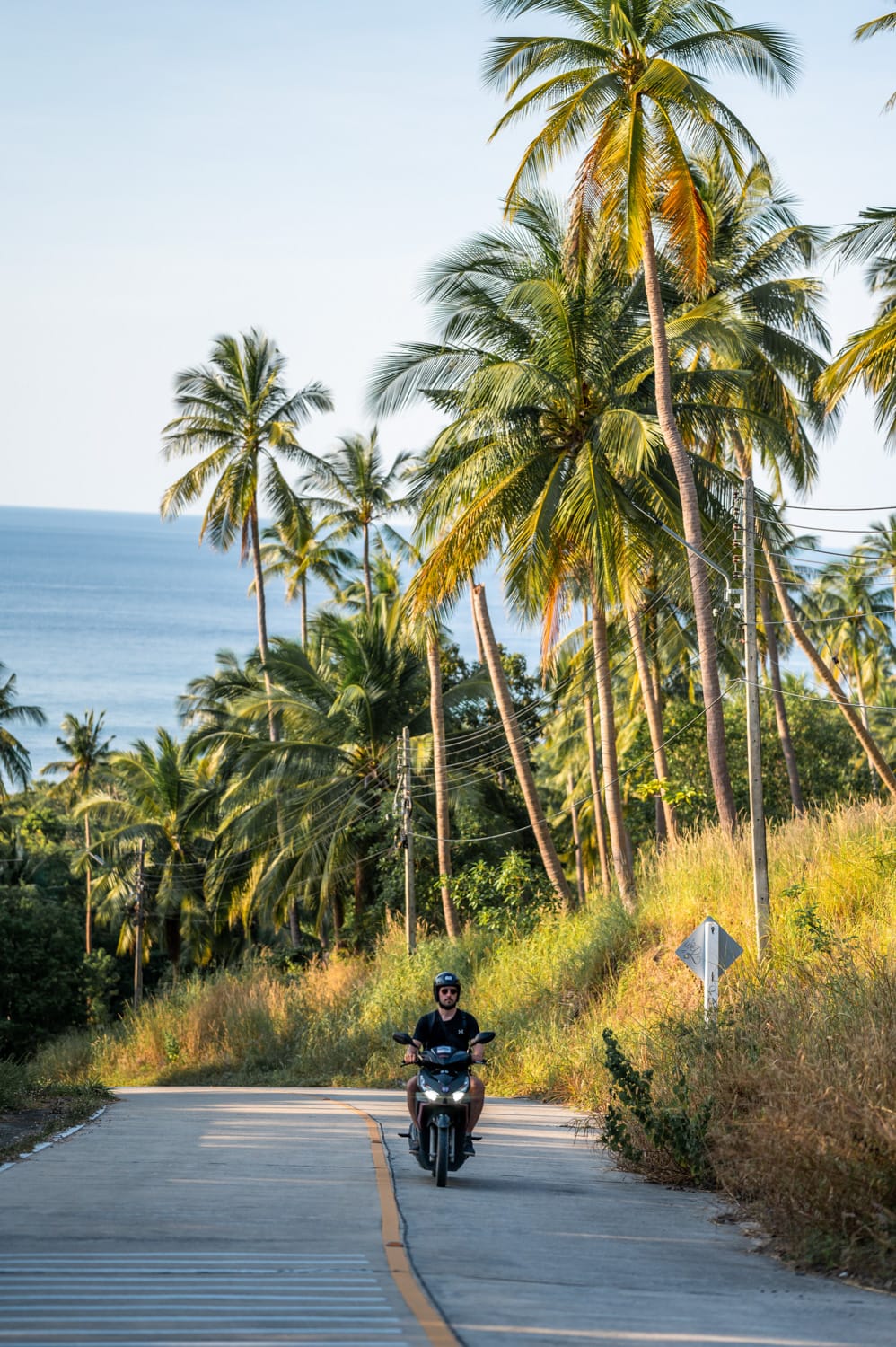 Nils Alexander Kemna fährt Roller auf einer sehr gut ausgebauten Straße in Thailand
