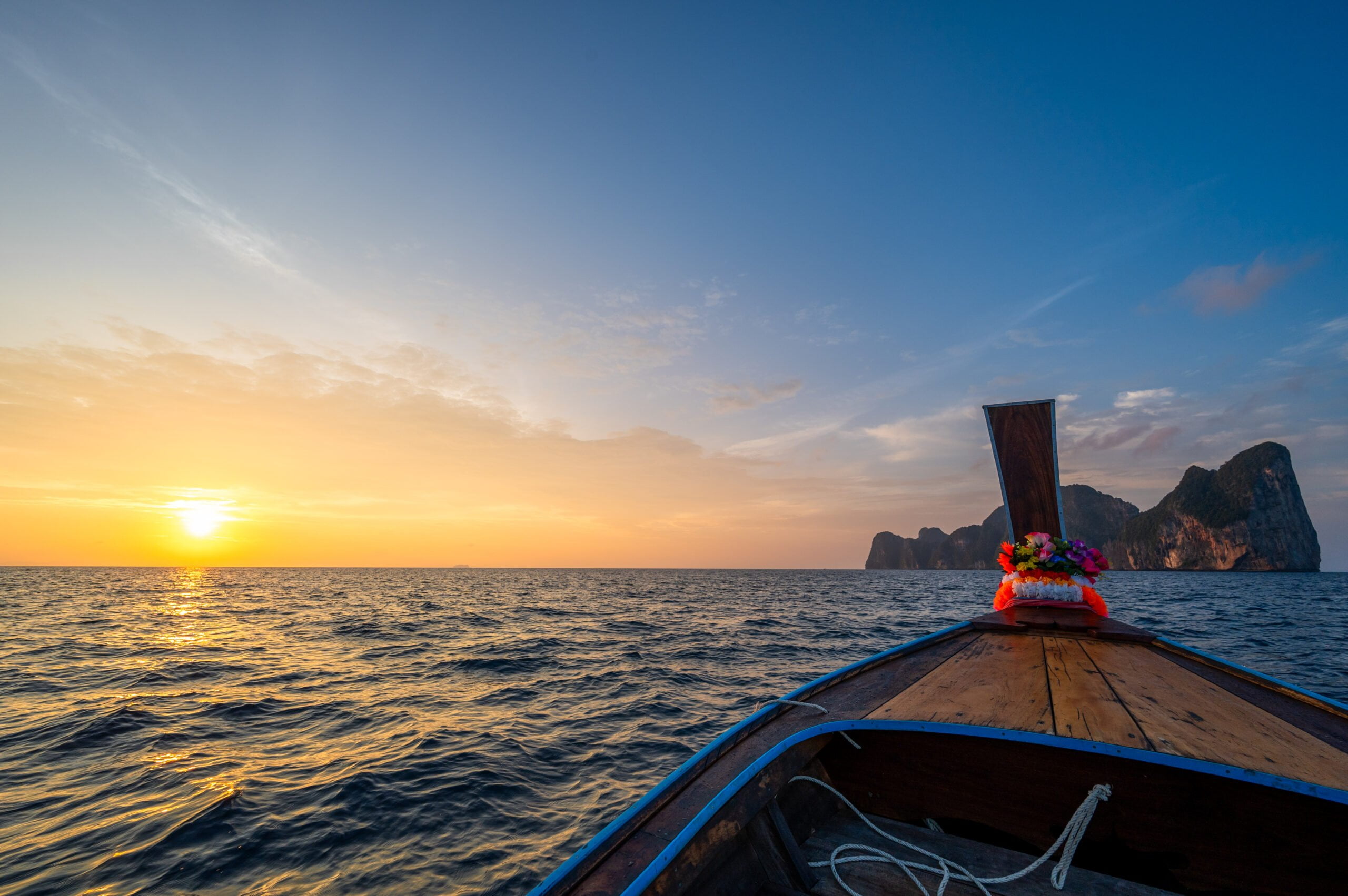 Longtailboot fährt während des Sonnenaufganges zur Maya Bay auf Koh Phi Phi Leh