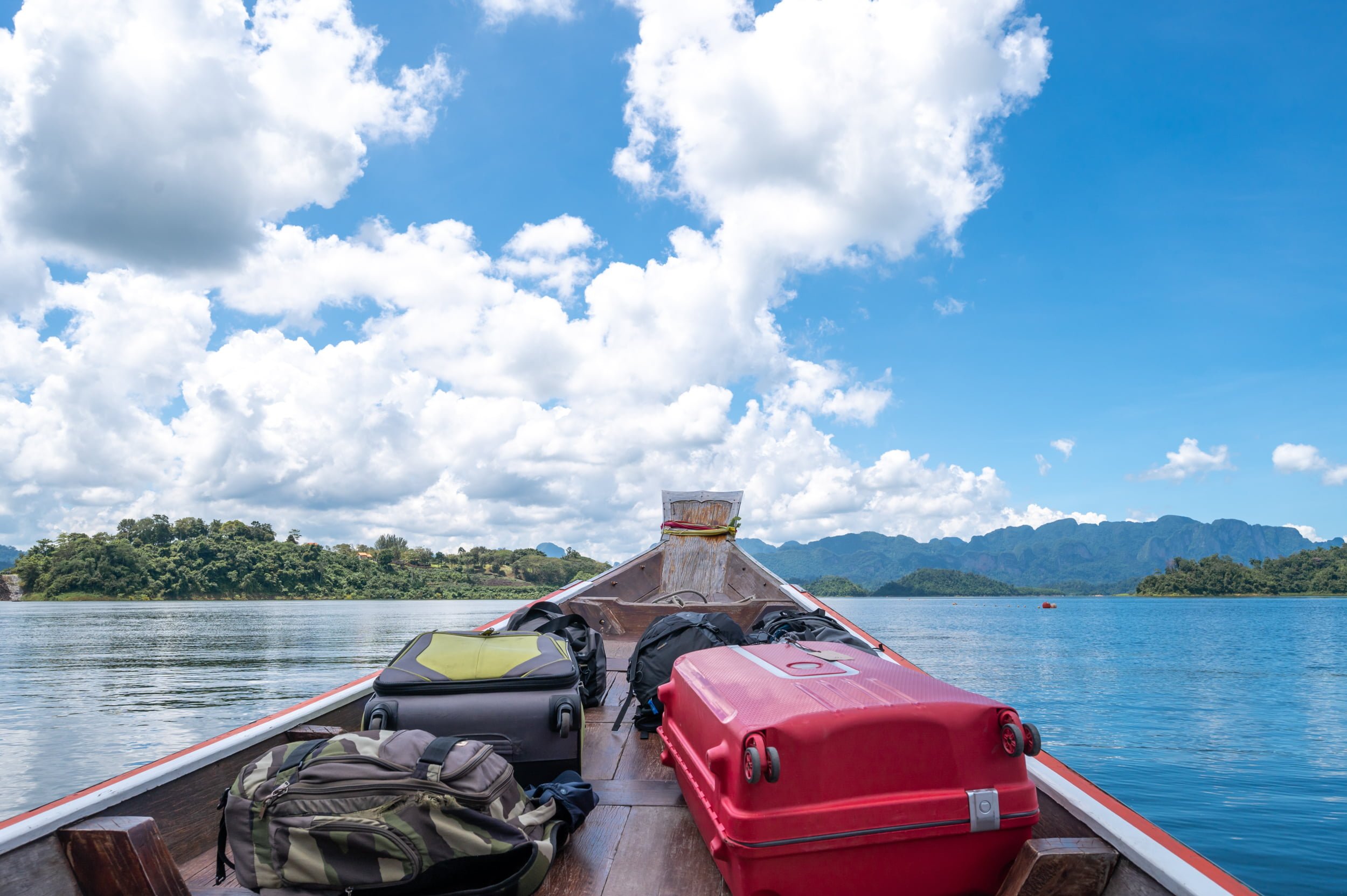 anfahrt zum schwimmenden hotel mit longtailboot Longtailboot auf dem Cheow Lan Lake transportiert Rucksäcke und Koffer zu einem Floating Bungalow