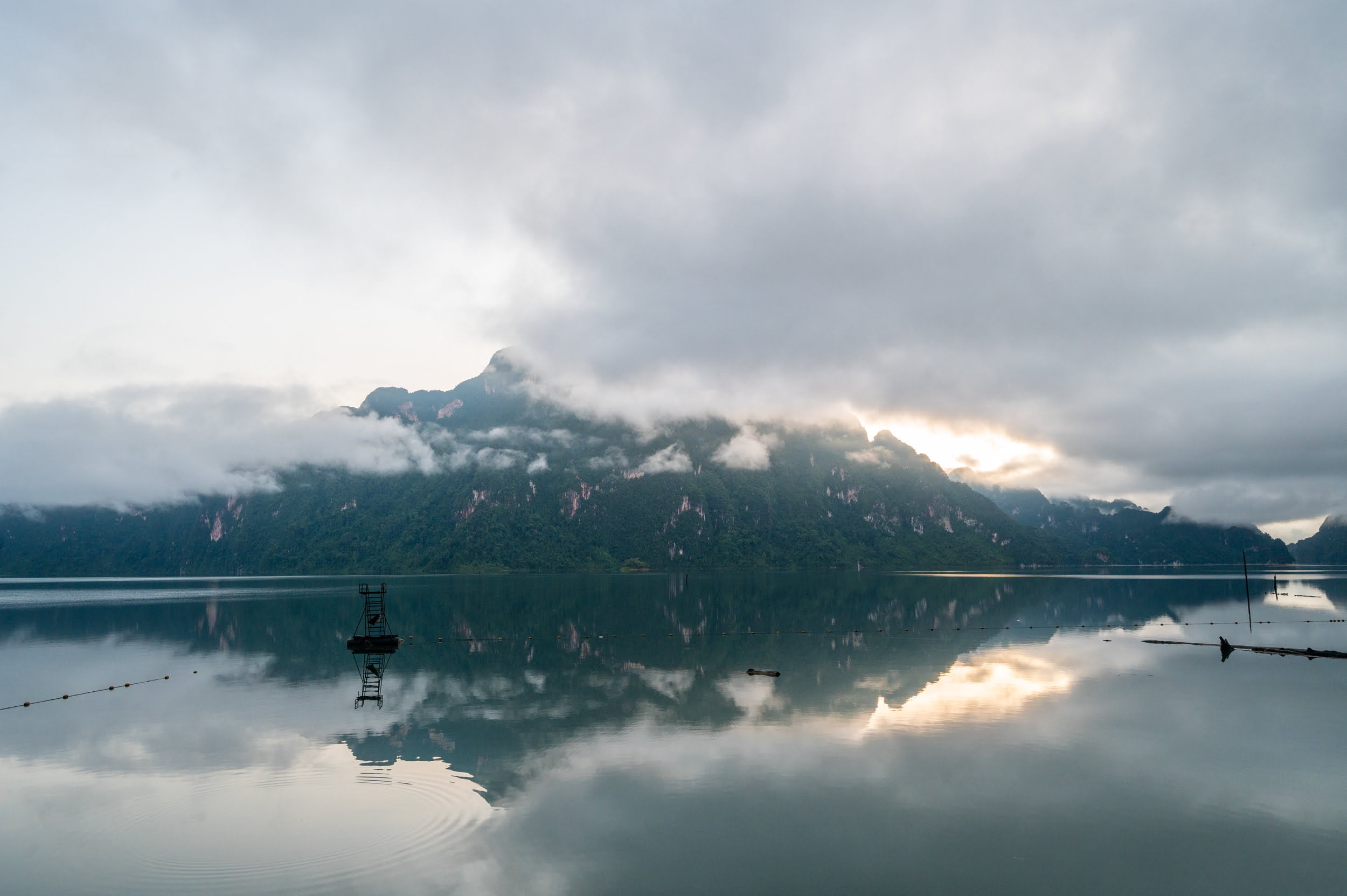 sonnenaufgang cheow lan lake Ausblick auf dichten Nebel vor einem Berg, fotografiert vom Panvaree Resort auf dem Cheow Lan Lake
