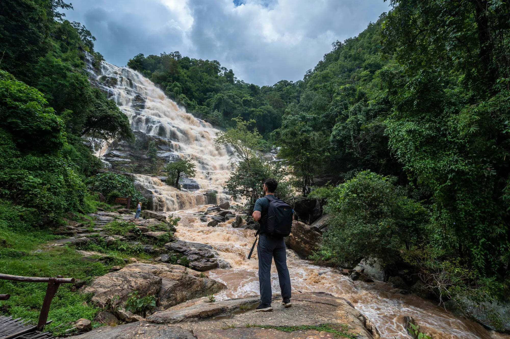 Alex blickt auf einen beeindruckenden Wasserfall in Nordthailand am Ende der Regenzeit