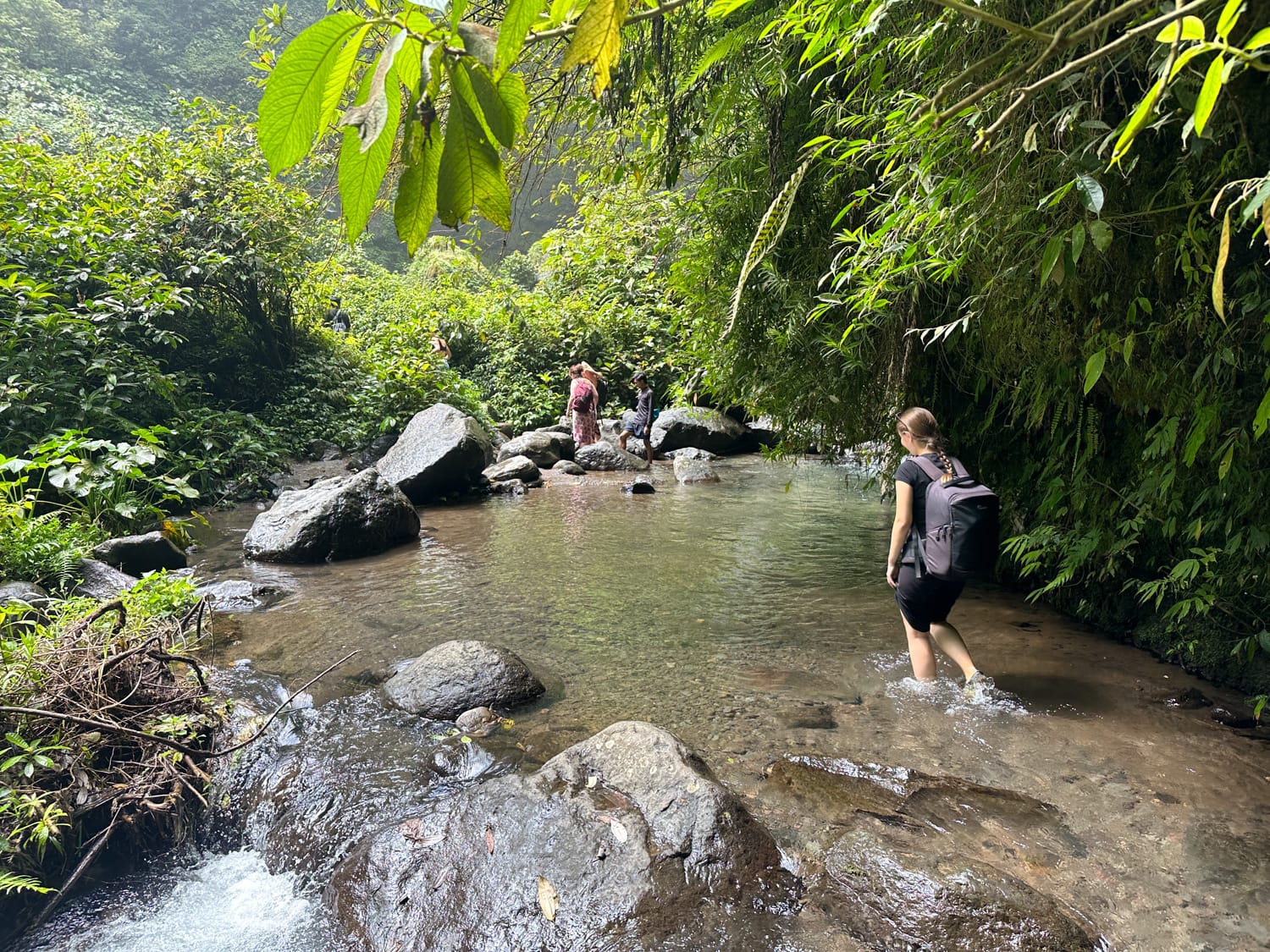 Vanessa Mosch läuft durch einen Fluss beim Wandern in Munduk