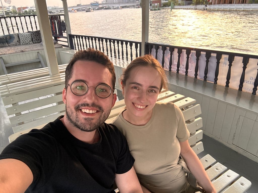 Vanessa und Alex von AlexAsia lachen in die Kamera, unterwegs mit dem Boot in Bangkok
