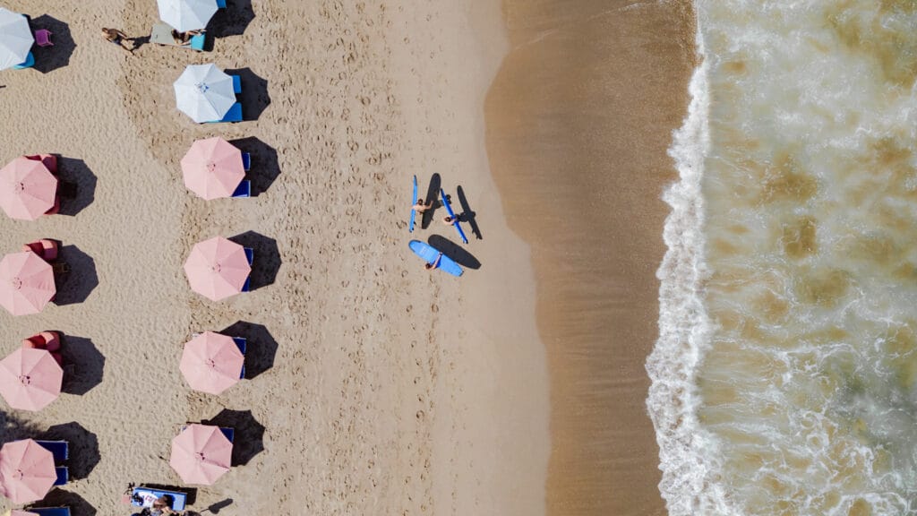 Surfer und Sonnenschirme am Batu Bolong Beach
