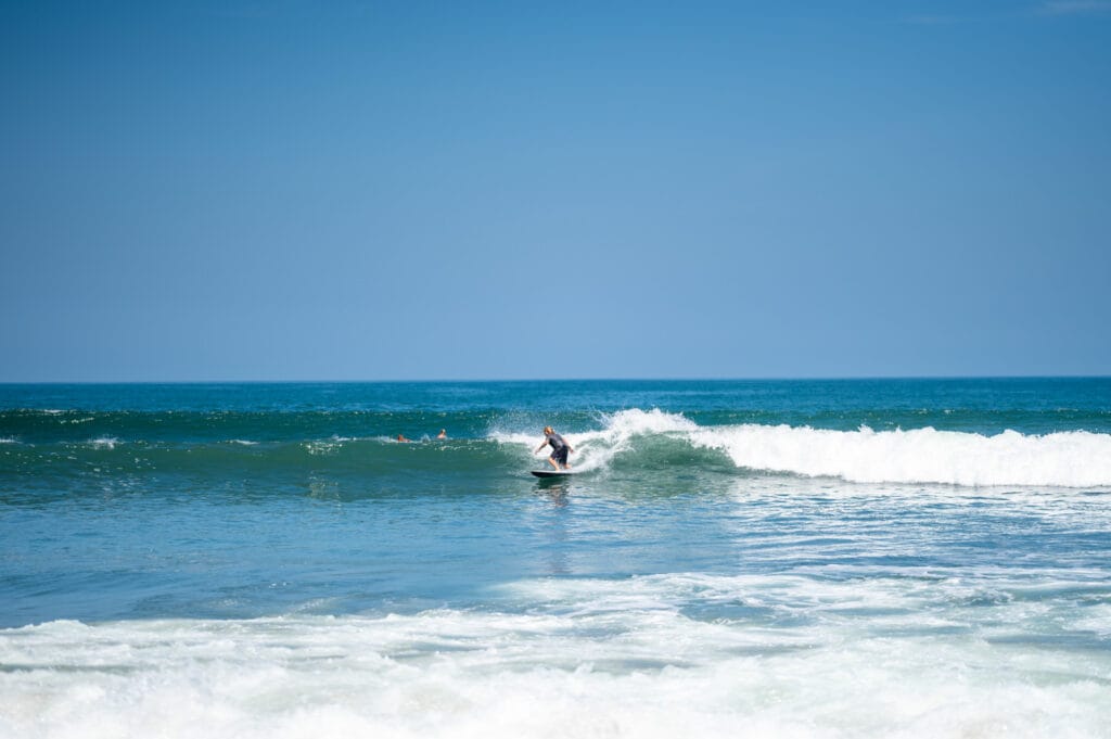 Surfer reitet eine Welle am Nelayan Beach