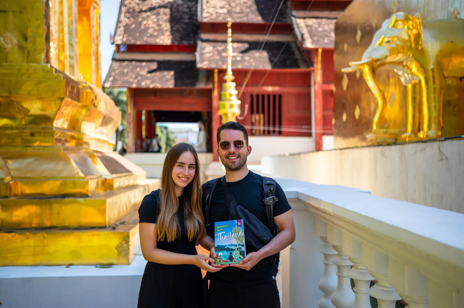 chiang mai (26) Vanessa Mosch und Nils Alexander Kemna halten ihren Thailand-Reiseführer im Wat Phra Singh in Chiang Mai
