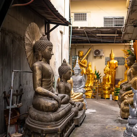 Buddha-Figuren aus Bronze und Gold in einer versteckten Gasse in Bangkok