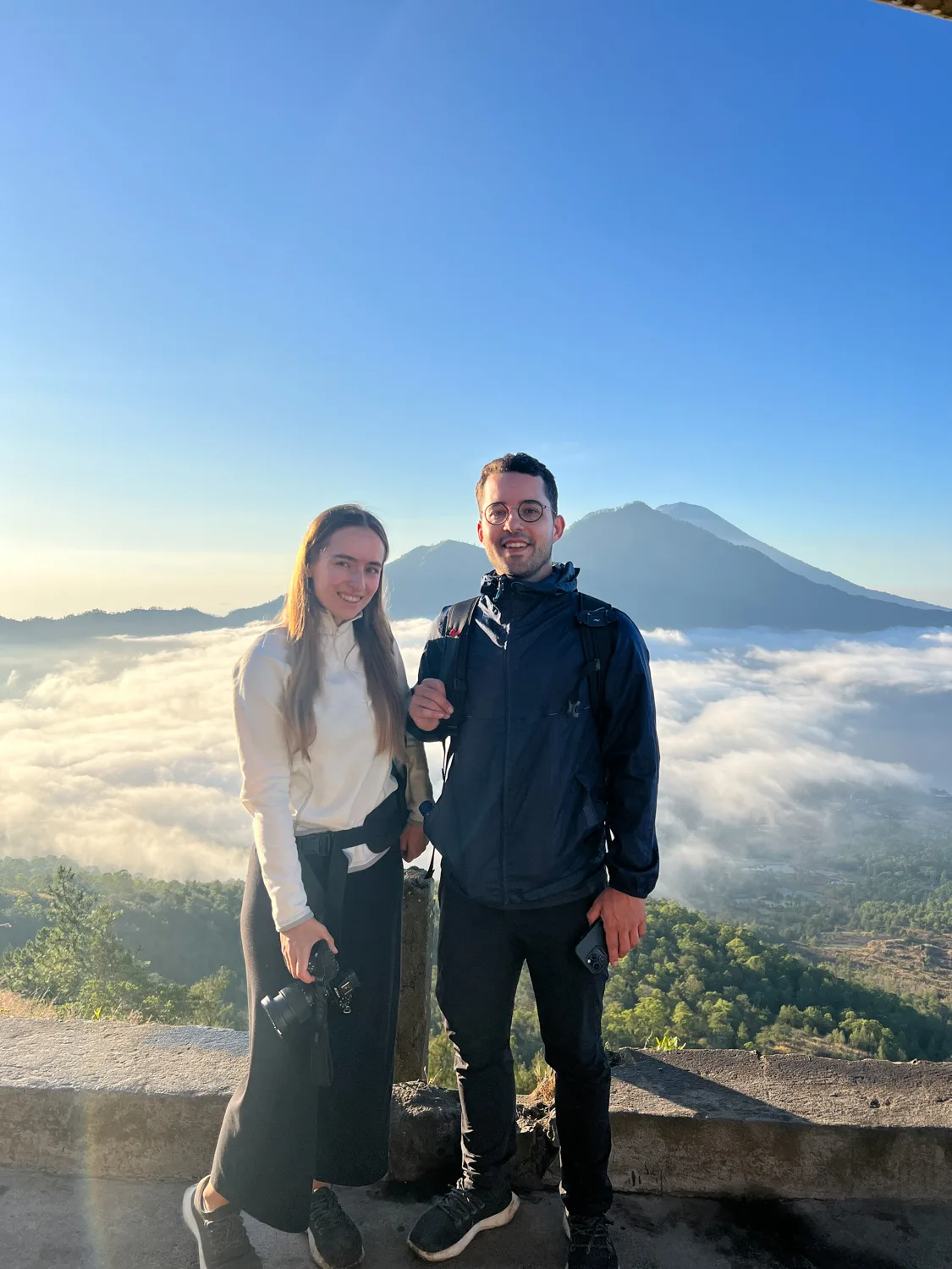Nils Alexander Kemna und Vanessa Mosch stehen vor Wolken beim Abstieg vom Mount Batur