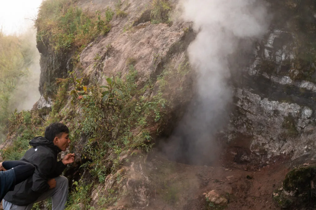 Lokaler Guide zeigt den Rauch im aktiven Vulkan Batur auf Bali