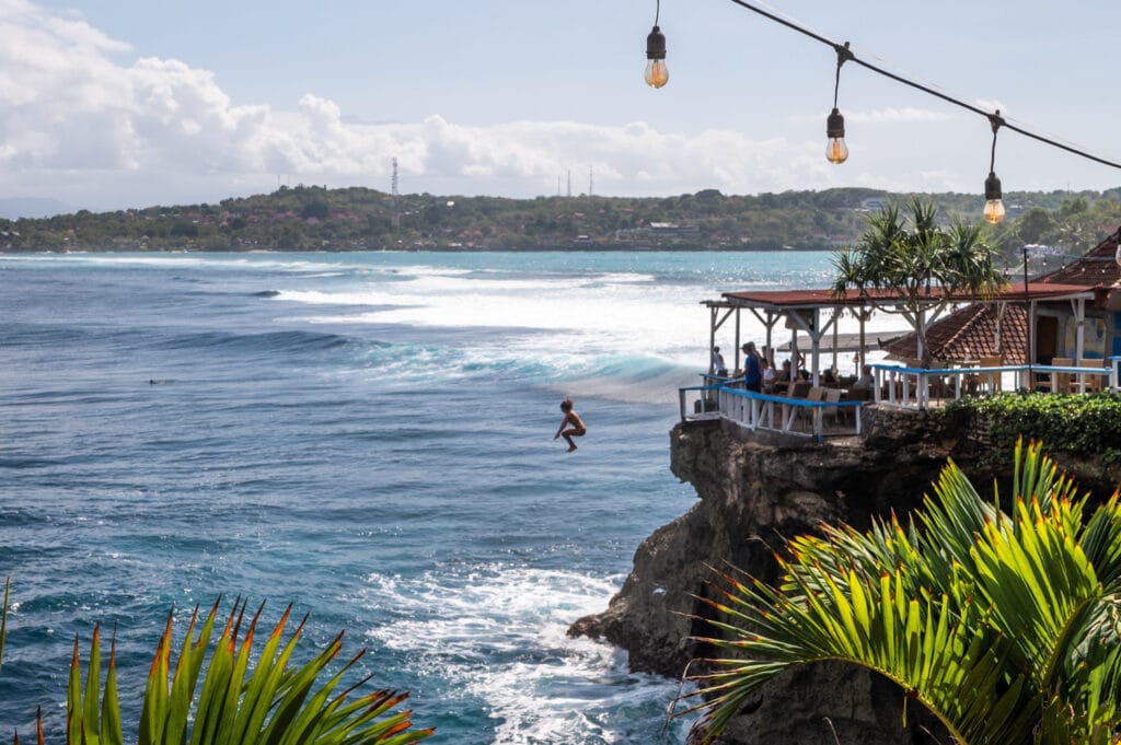 Frau springt am Mahana Point ins Meer