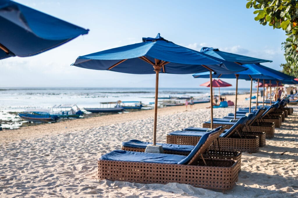 Sonnenliegen entlang des Jungutbatu Beach bei Ebbe