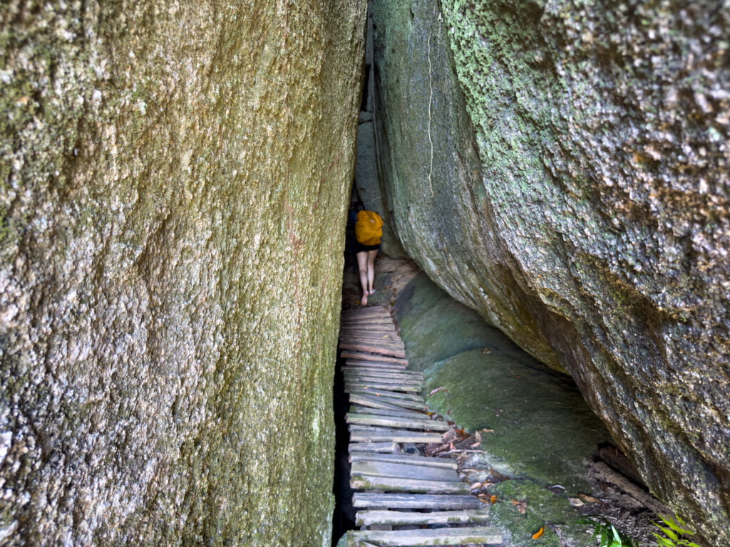 Vanessa durchquert eine Felssaplte auf dem Weg zum Lan Ka Luang Viewpoint