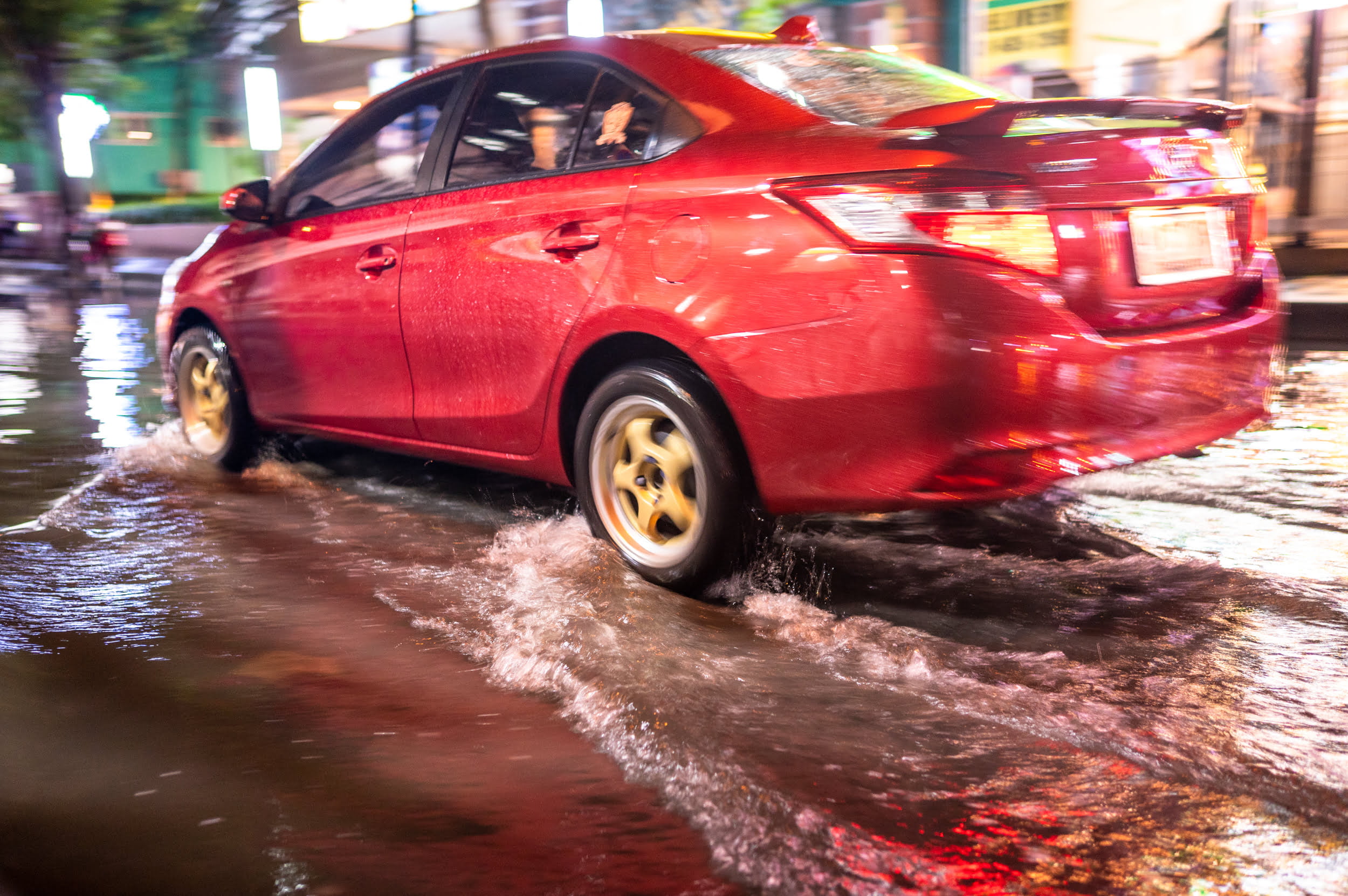 auto in überschwemmter straße auf reise nach thailand im august